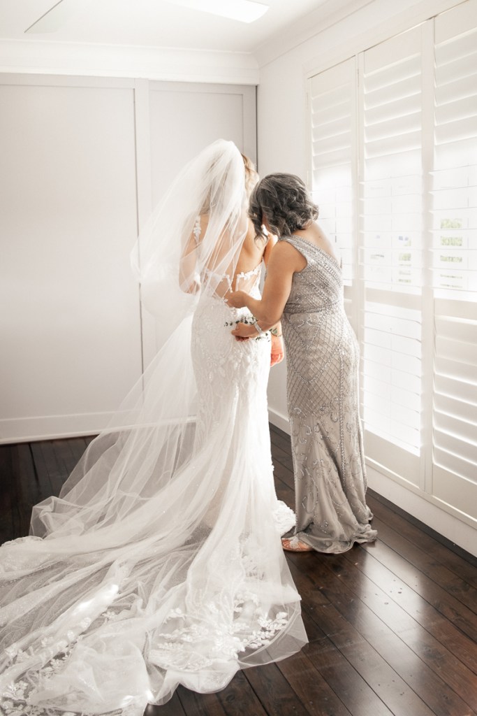 Bride having her veil adjusted during wedding preparations, captured with natural wedding photography in Wollongong