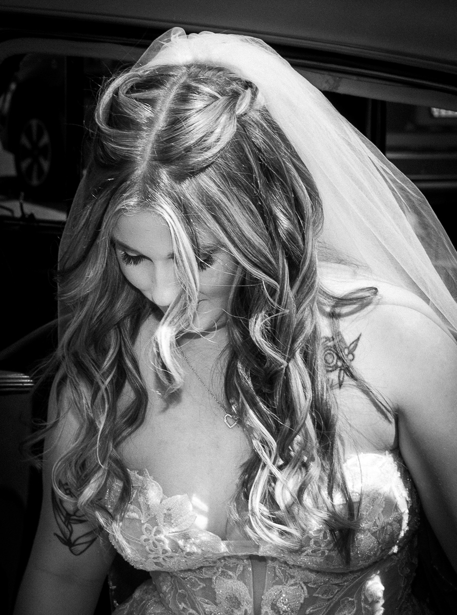 Bride looking down and coming out of the car photographed by Olivia Holley Studio