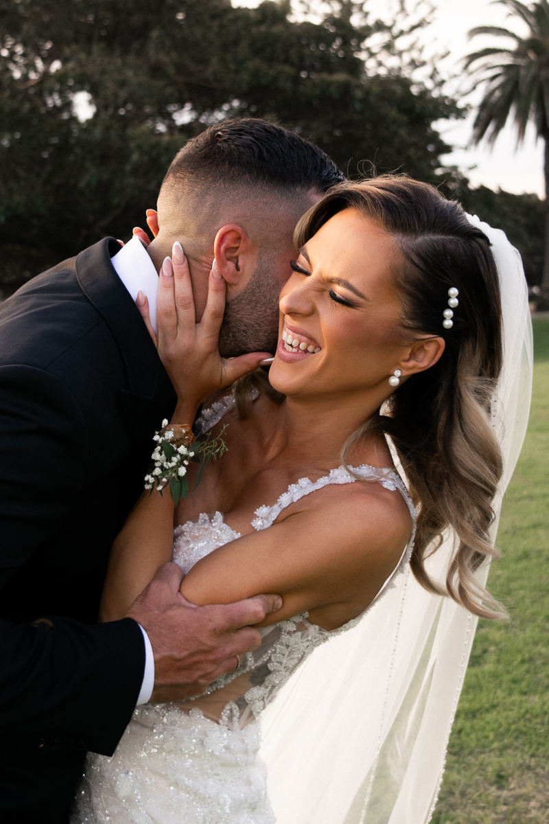 The groom kissing the brides neck and her laughing photographed by Olivia Holley Studio