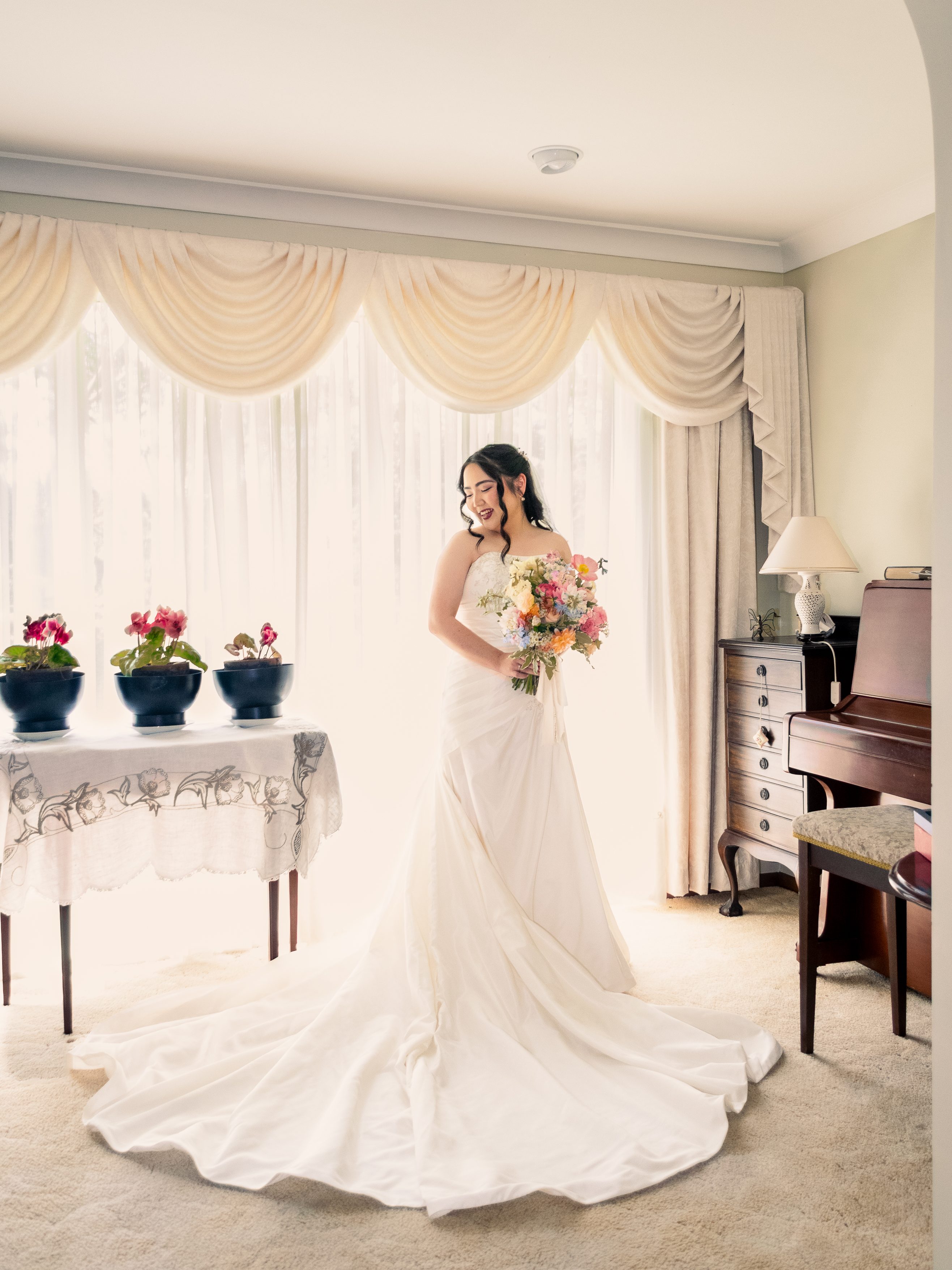 Bride holding her bouquet during an indoor wedding portrait, photographed with soft natural light